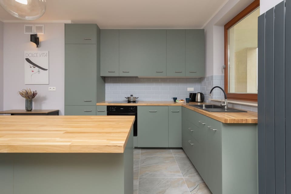 A compact and functional kitchen corner with modern appliances and green accents.
