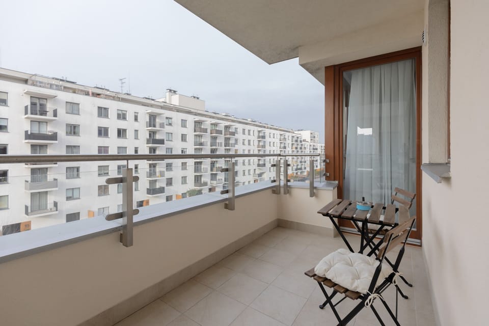 A balcony with outdoor seating, offering views of the surrounding residential area.
