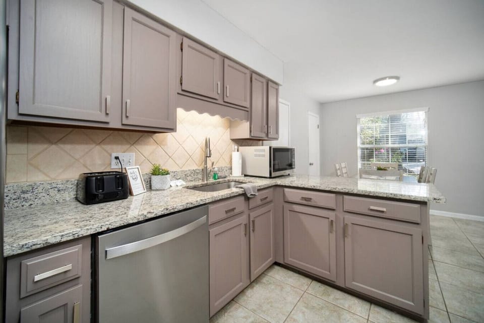 Enjoy a well-lit kitchen with ample cabinet storage, stylish granite countertops, and a welcoming dining area just steps away.