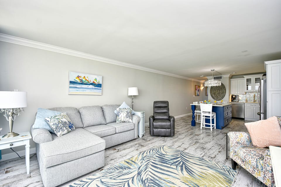 Living room has a chaise and a swivel rocker recliner along with extra seating. 