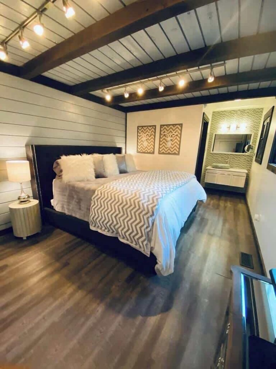 Relax in this spacious bedroom with direct access to a chic en-suite bathroom. The soft lighting, cozy decor, and comfortable bedding create a perfect haven for unwinding after a busy day.