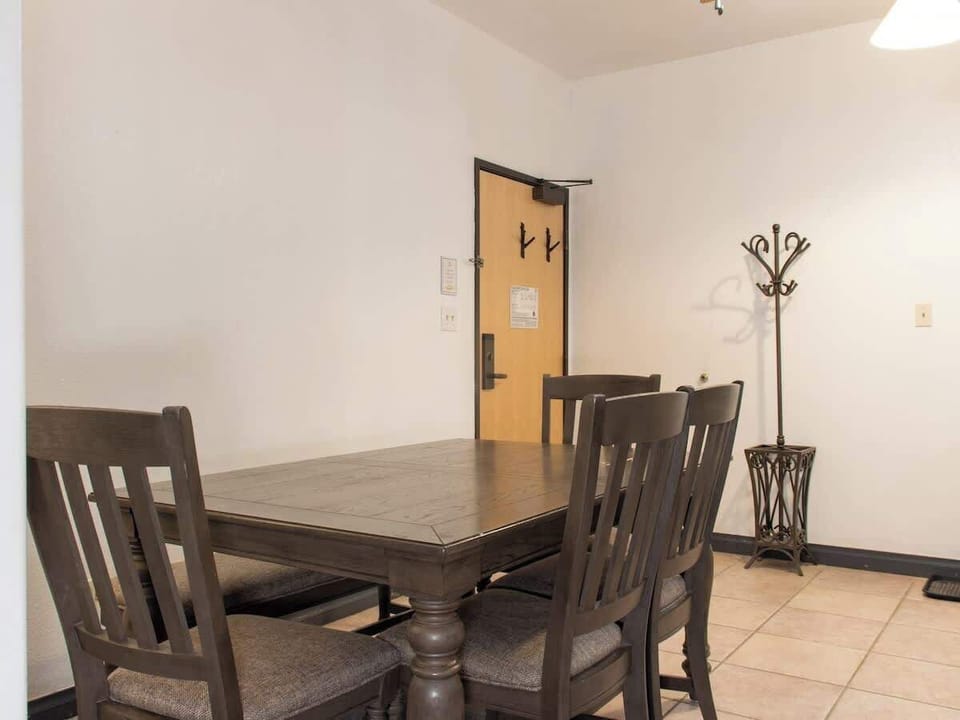 Enjoy memorable meals in your inviting dining area. The cozy wooden table and chairs offer the perfect spot to gather for a hearty breakfast or a delightful dinner, creating a warm and welcoming atmosphere for your stay. (Entryway + dining area)