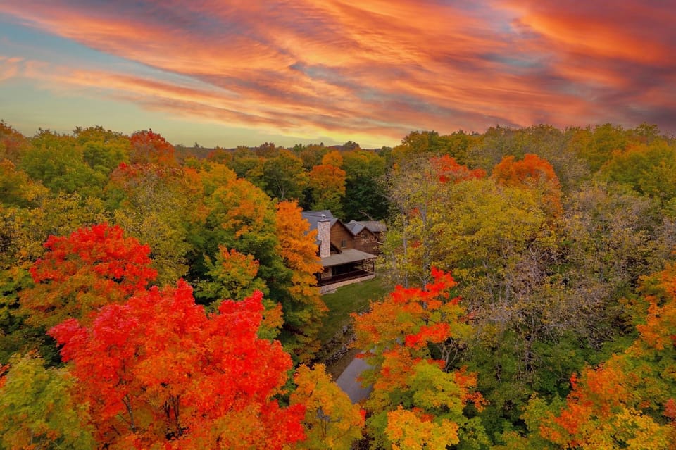 Aerial view showing the home surrounded by mature trees on a private 13-acre property.