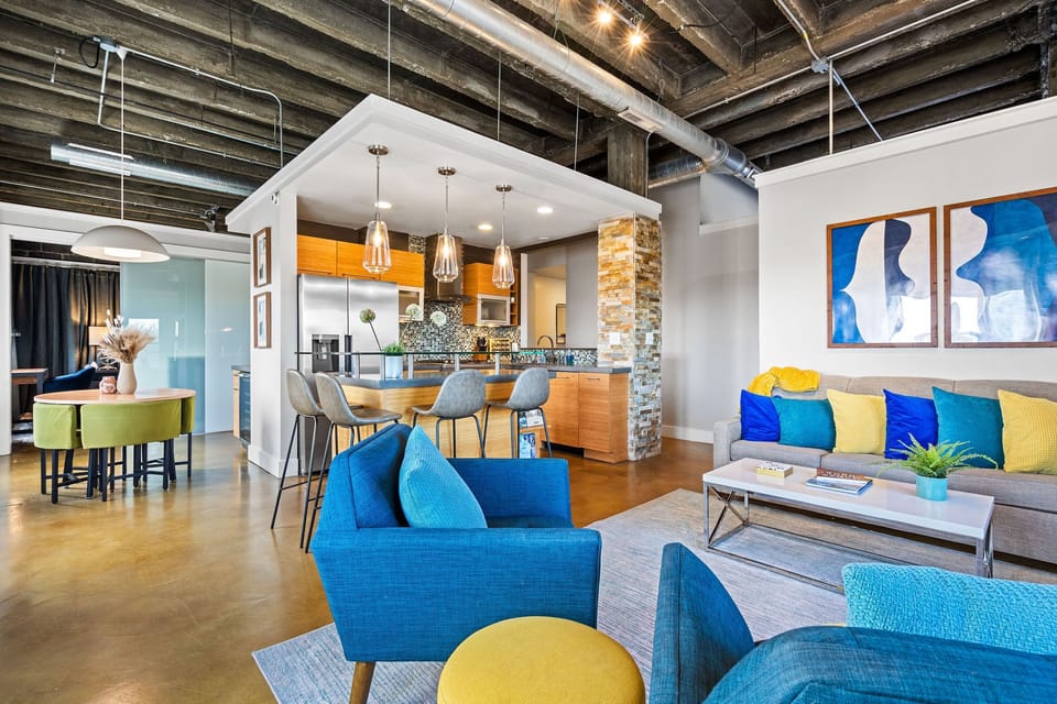 Loft-inspired living room with direct sightlines to the chef’s kitchen, blending historic charm with modern design on the building’s top floor.
