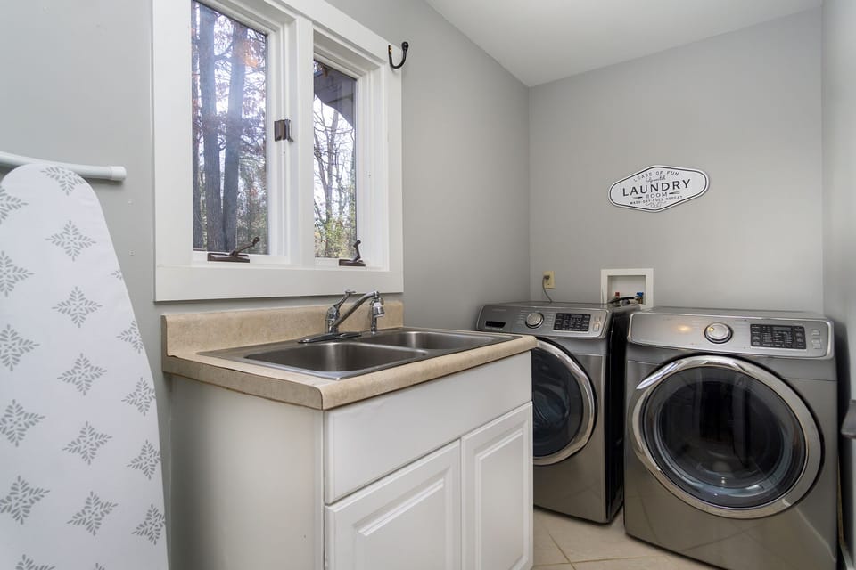Full size laundry room with ironing board and iron for your use.