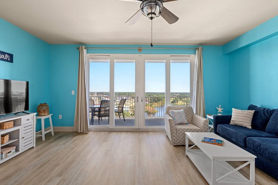 Spacious living room, LVP floors, sleeper sofa, chairs, and balcony. 