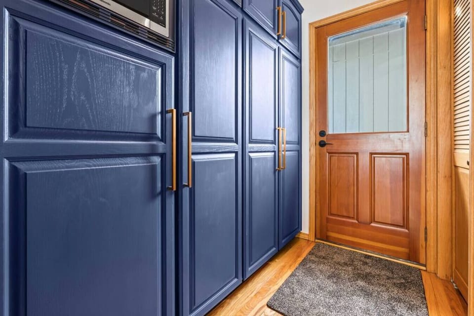 Large pantry stocked with an abundance of kitchen items, and a side door which also leads to the front of the home.