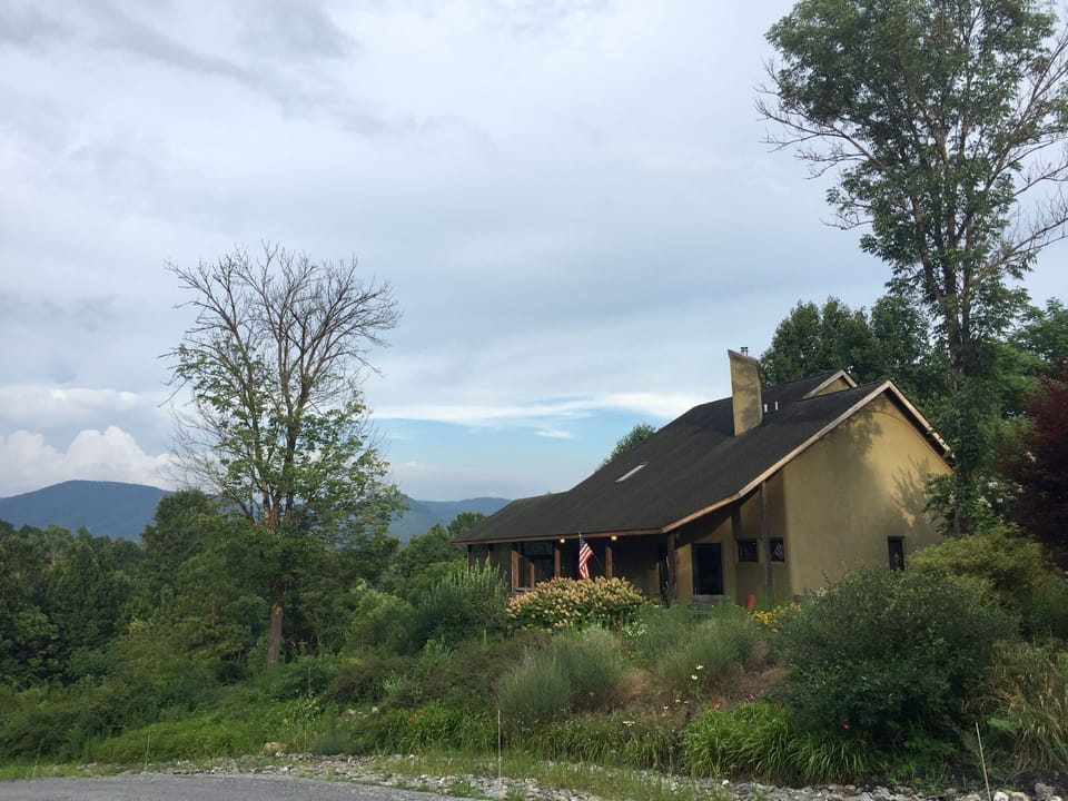 House is nestled into the hill, looking out on the Blue Ridge Mountains