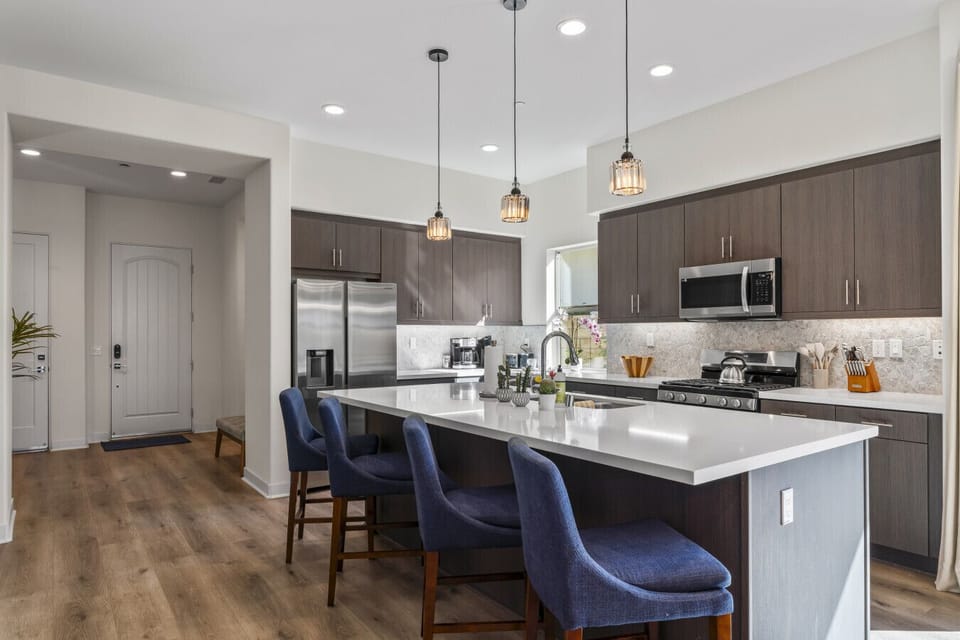 Bright kitchen w/ large island seating & modern finishes, ideal for cooking & gathering together