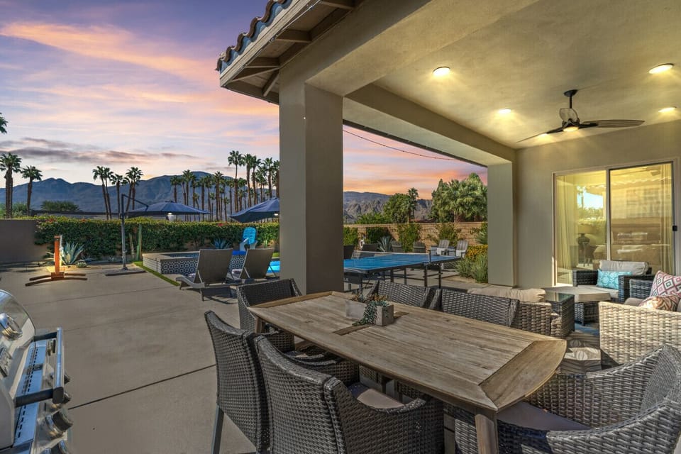 Lounge under the covered patio w/ cozy seating & twinkle lights at dusk