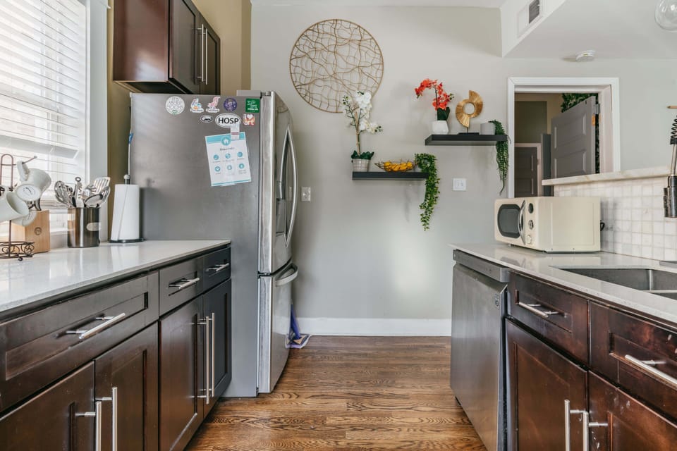 Stainless steel fridge and freezer in full kitchen.