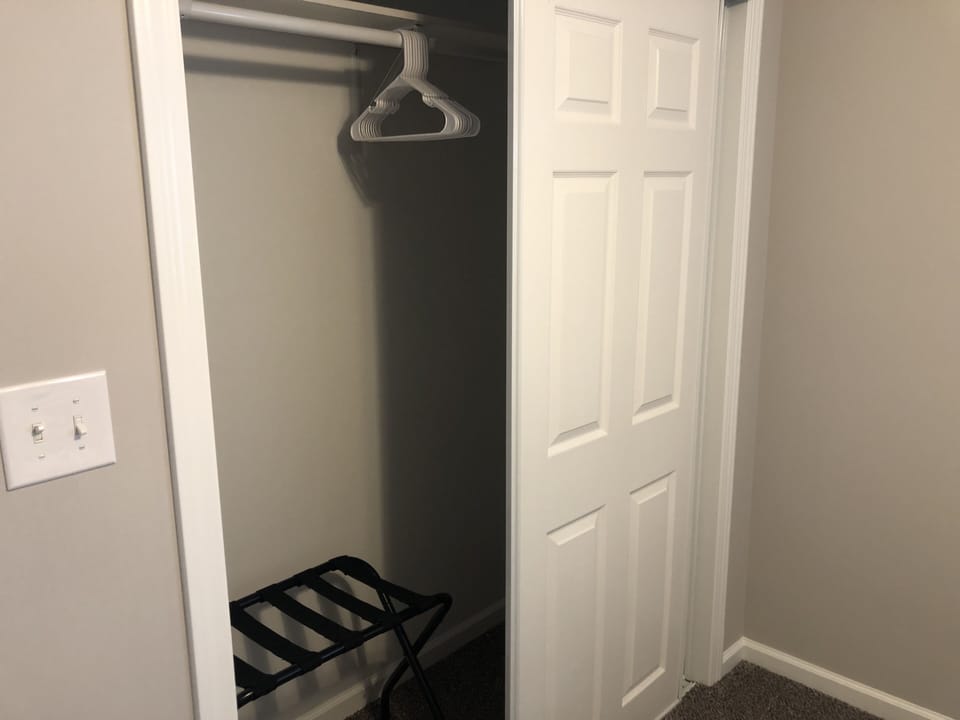 Closet in second bedroom with hangers and luggage rack