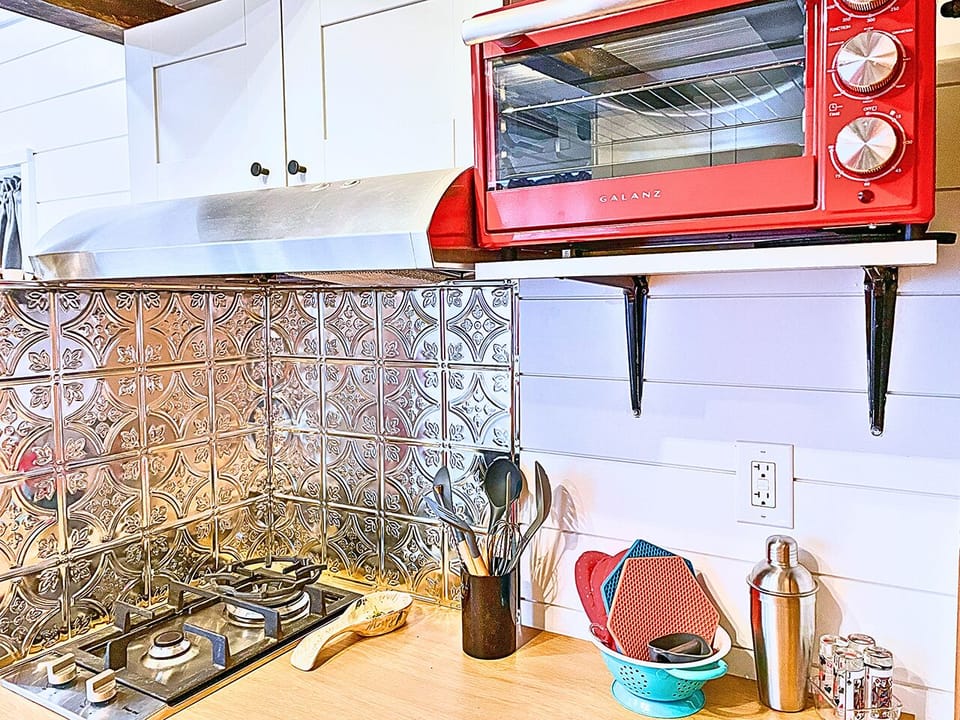 Fully Equipped Kitchenette: Utensils, Stove, and Plates