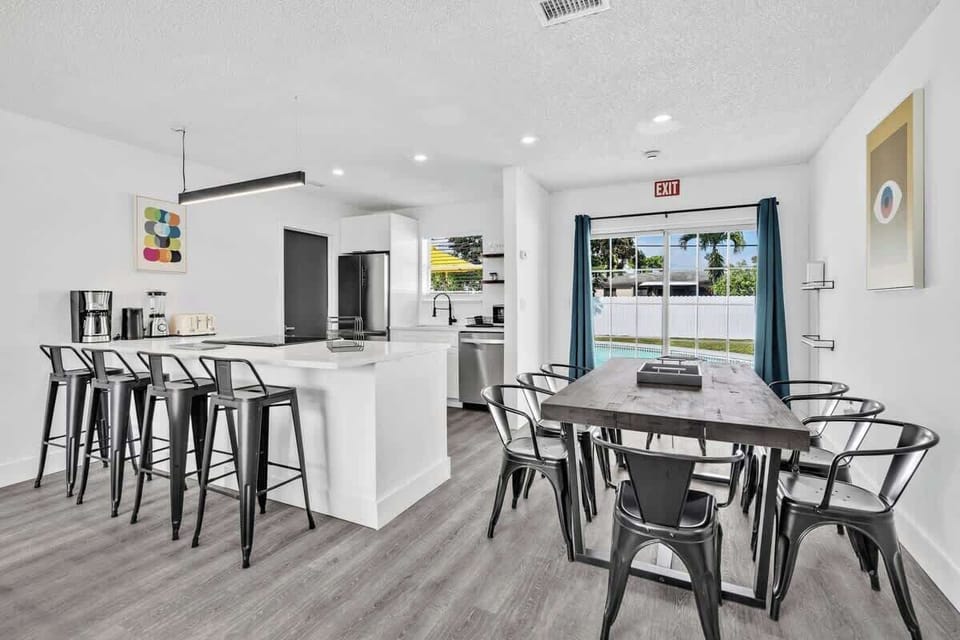 Cook, sip, and dine in this bright kitchen-dining space with pool views and a cozy coffee station.