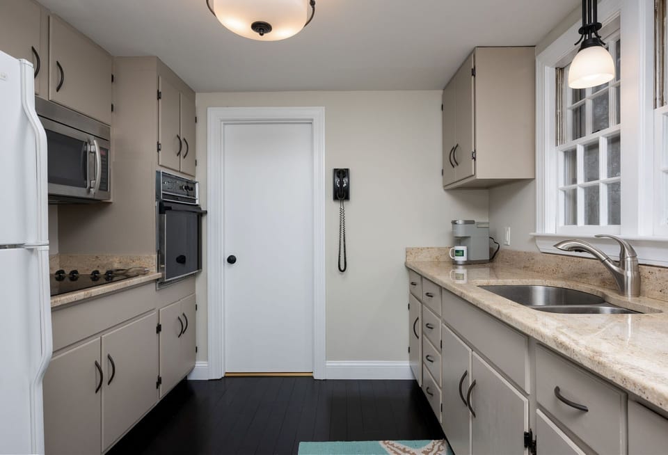 Spacious galley kitchen with a bathroom on the far side that is also connected to the hallway - 177 Old Stage Road Centerville Cape Cod - Family Tides - New England Vacation Rentals