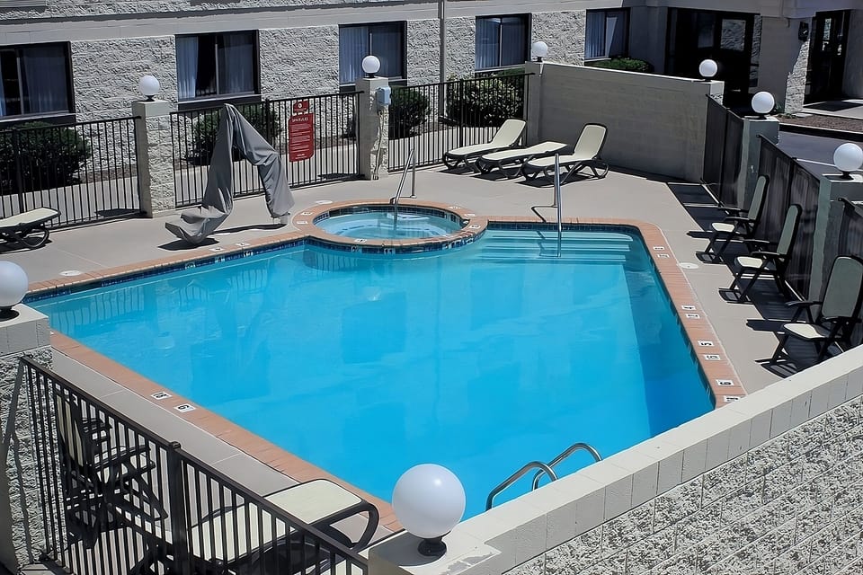 Dive into sunlit relaxation with sparkling pool and loungers.