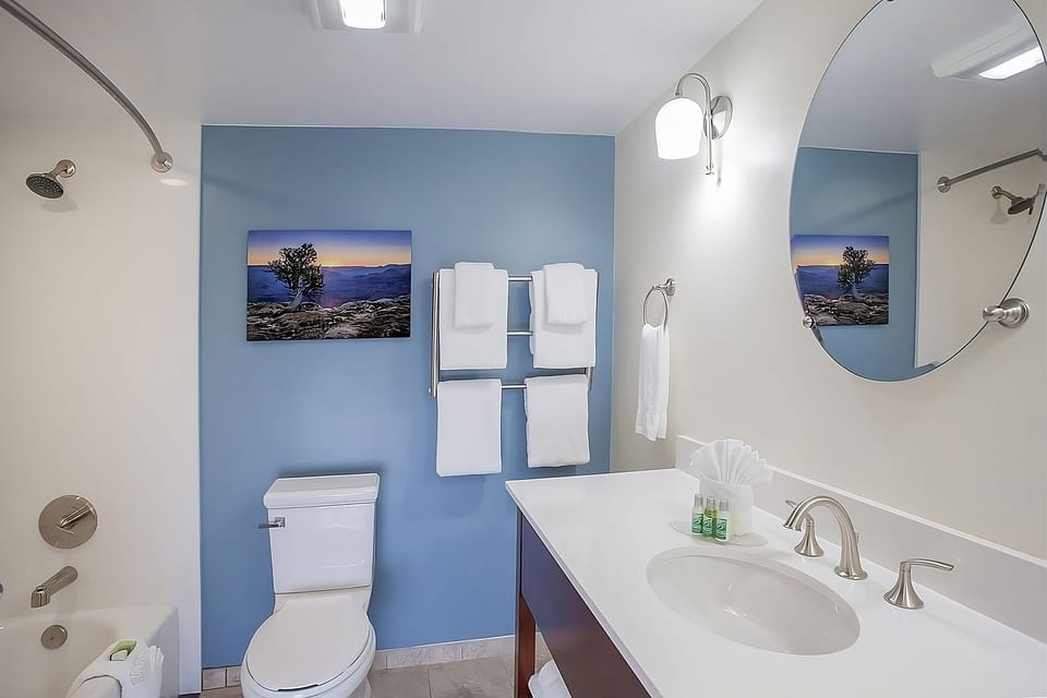 Refresh in a spotless bath with plush towels and bright vanity.