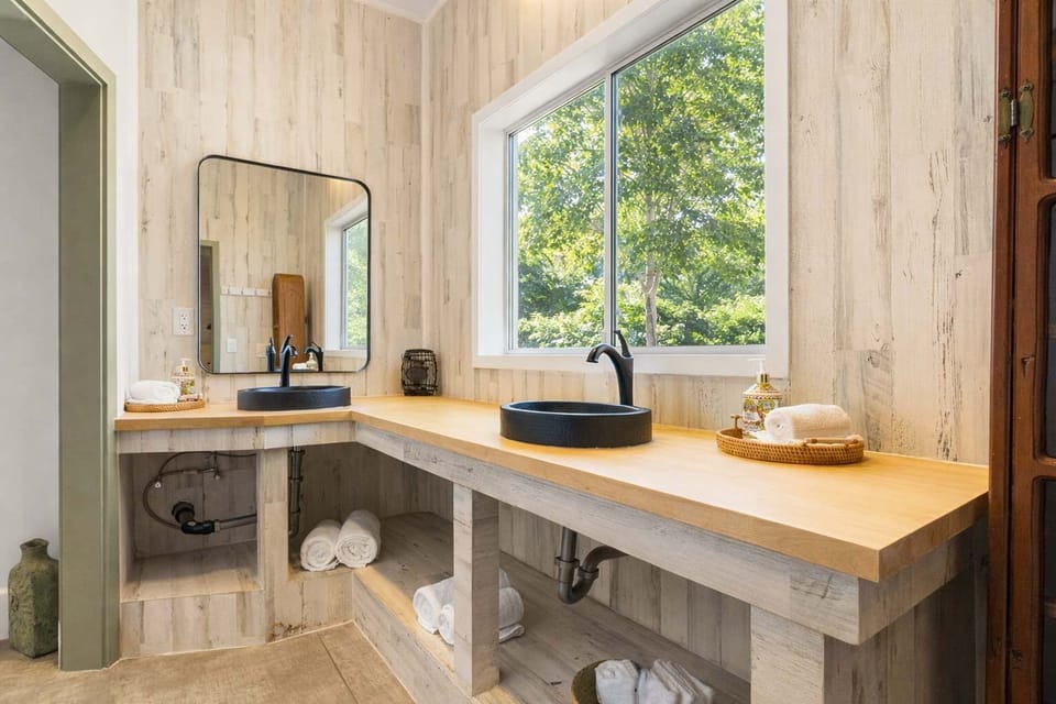 Monastery Bathroom with Dual Sink Vanity, Natural Wood Countertops, and Bright Window Light