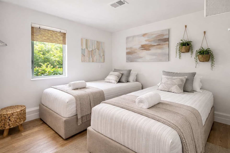 Bright Twin Bedroom with Two Single Beds, Fresh Linens, and Calm Coastal Atmosphere

