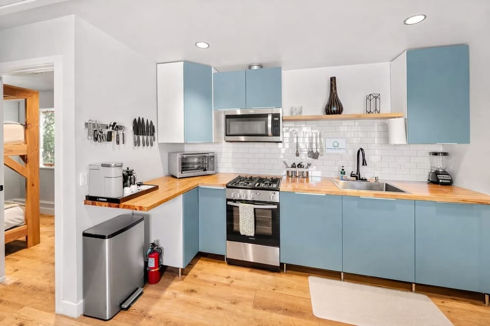 Stylish Full Kitchen Featuring Custom Blue Cabinets, Modern Appliances, and Clean Coastal Design