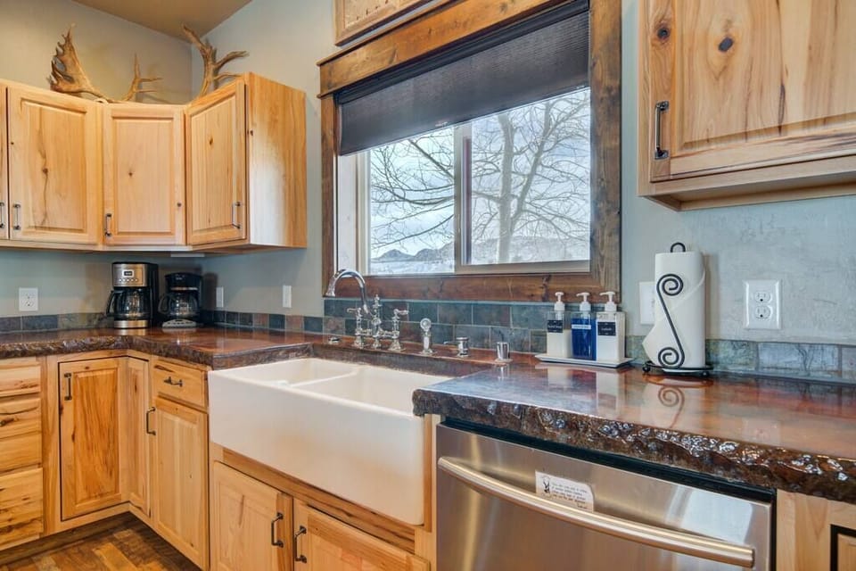 A large farm sink and stainless steal dishwasher make clean up a breeze in this kitchen. 