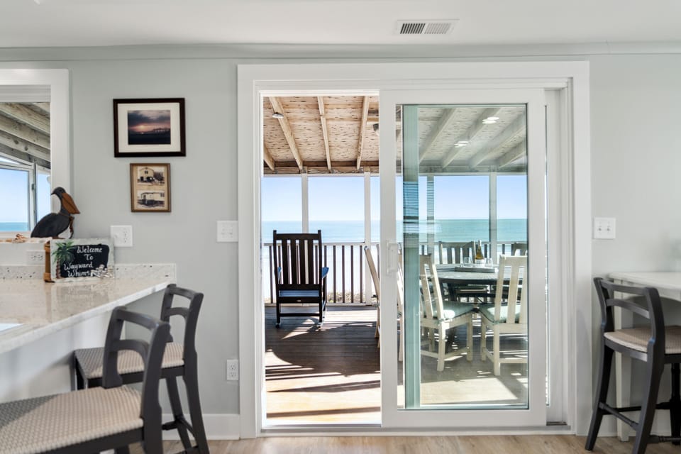 Sliding glass doors leading from the living room to the oceanfront screened in porch.