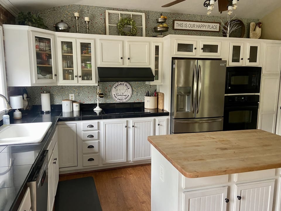 Kitchen with a bar that has two bar stools ( missing from photo)