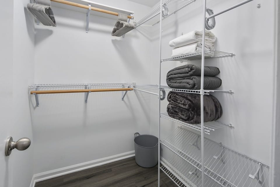 Walk-in-closet is home to extra bed sheets & throw blankets
