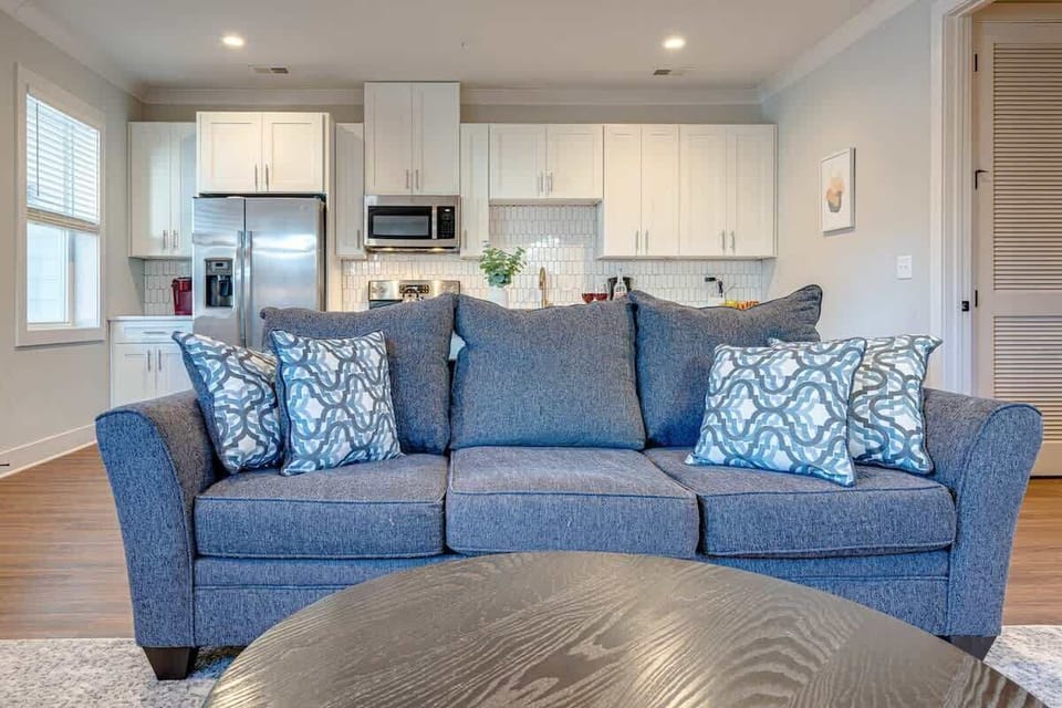 Open-floor plan featuring the cozy living room furnishings with a Smart TV seamlessly connecting to the fully equipped kitchen.