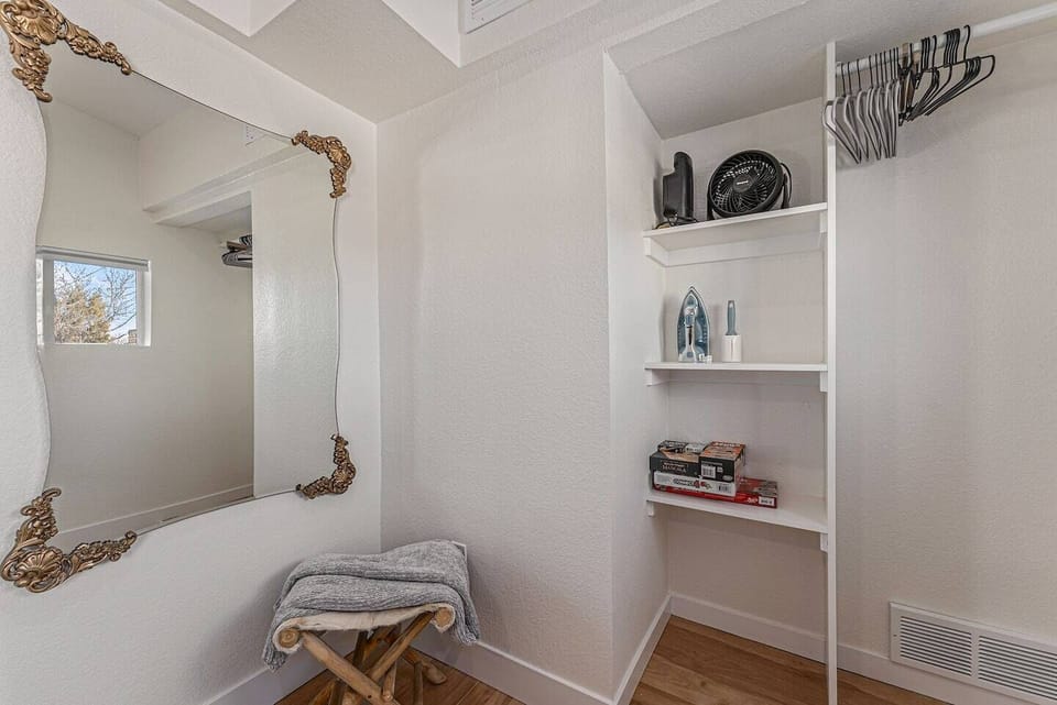 - Open closet nook offers handy storage shelves with games, décor, and essentials neatly arranged
- Classic mirror adds depth while the bench offers a place to rest or set your bag
- Ideal for guests who appreciate thoughtful design and practicality
