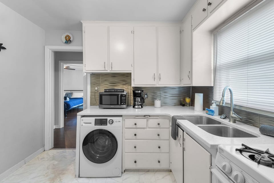 Kitchen with small 4 burner Stove and Oven, Clothes Washer, Microwave, Fridge, and Coffee Maker