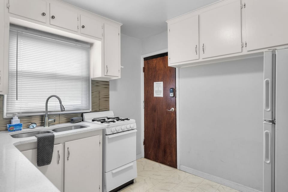 Kitchen with small 4 burner Stove and Oven, Clothes Washer, Microwave, Fridge, and Coffee Maker