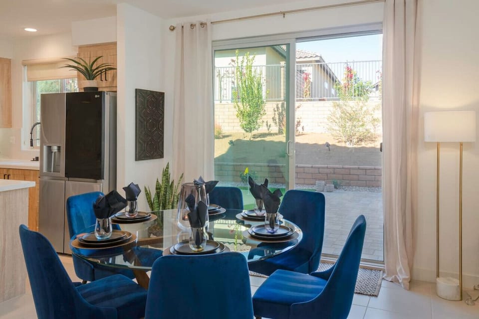 Dining area w/ elegant table setup & sliding doors opening to the outdoor space