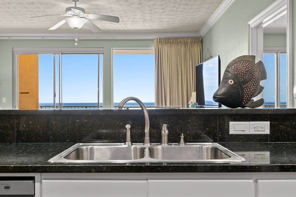 Modern kitchen sink area with ocean views through large windows