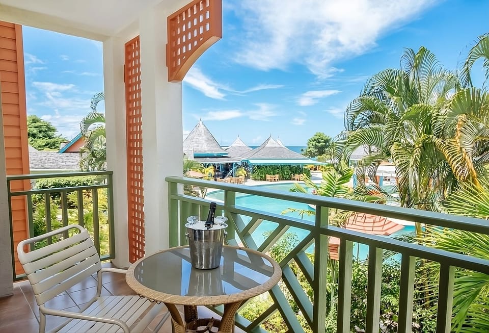 Sip morning coffee on the balcony overlooking tropical pools.