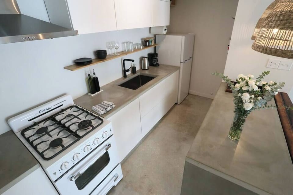 Fully stocked and ready to go—this compact kitchen includes a gas stove, open shelving, and all your cooking essentials.
