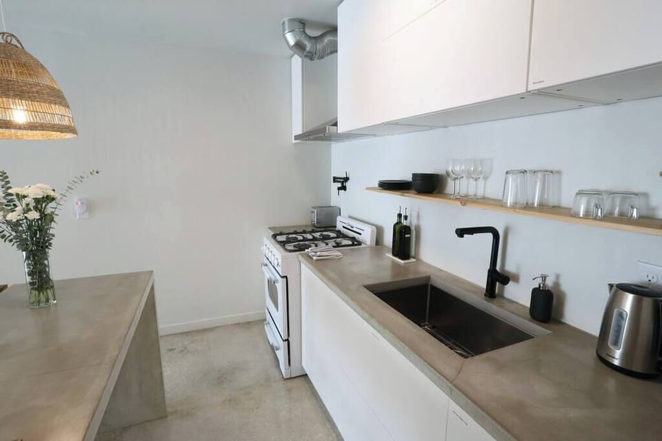 Cook with ease in the sleek, modern kitchen featuring open shelving and stainless steel touches.