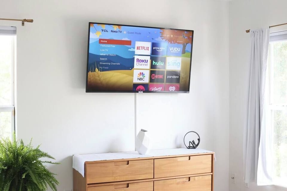 Relax after a long day with your favorite shows on the smart TV in this sunlit, stylish bedroom.