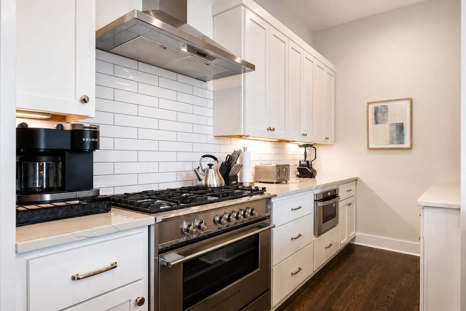 Cook, entertain, and enjoy in a modern white kitchen with stainless appliances.