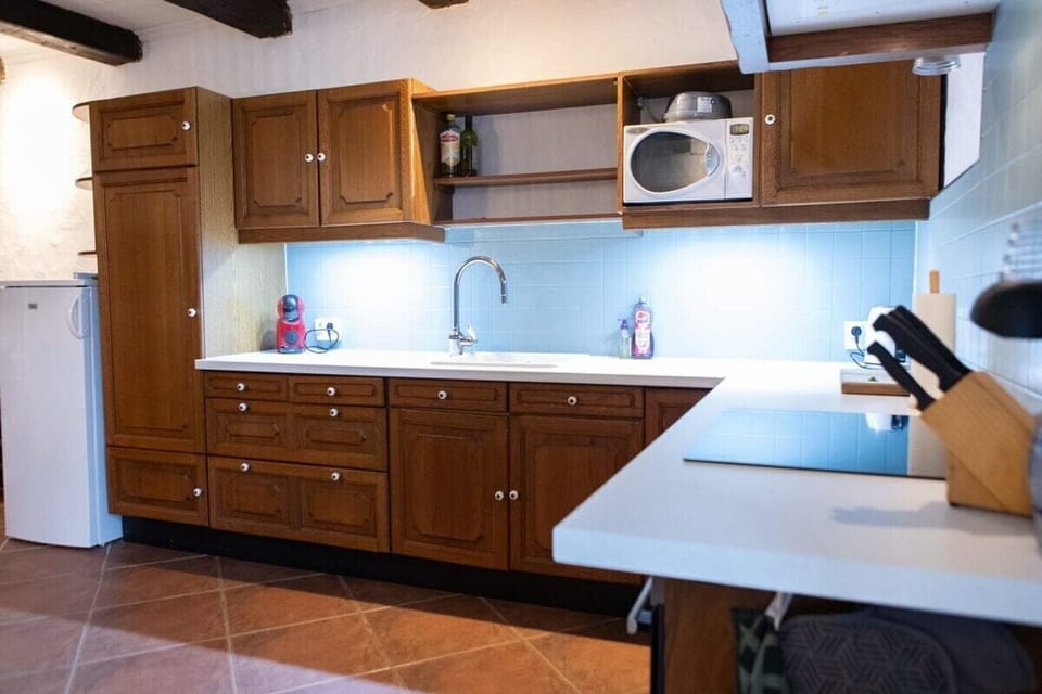 Fully equipped kitchen with microwave, oven, electric hob and a large dining table.