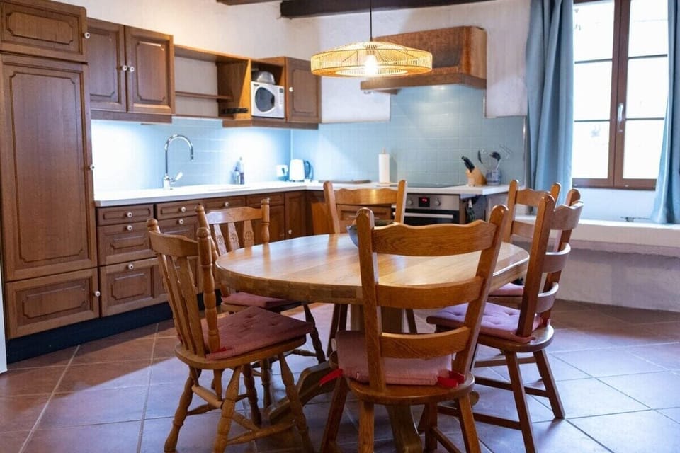 Fully equipped kitchen with microwave, oven, electric hob and a large dining table.