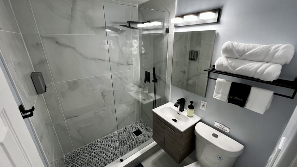 Modern spacious shower with rain shower overhead and Handheld Sprayer