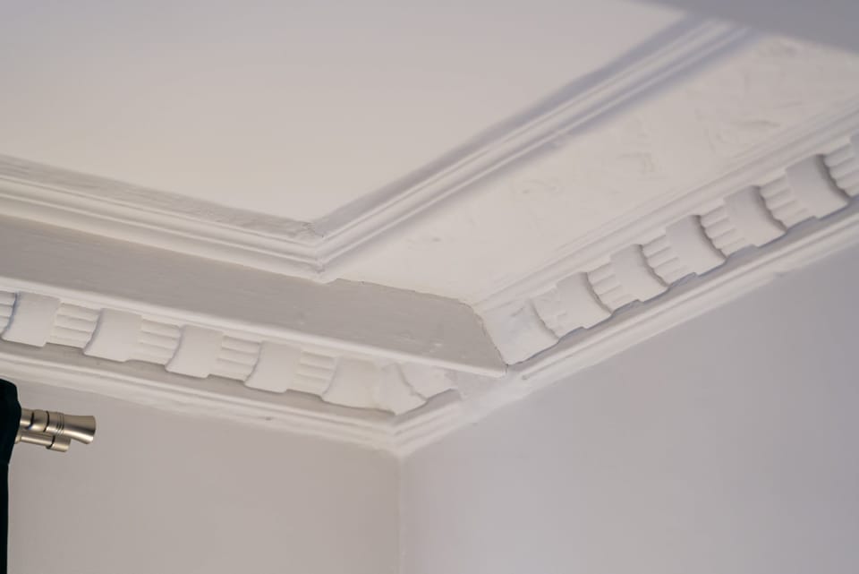 A detailed look at the ceiling, showcasing intricate architectural moldings.
