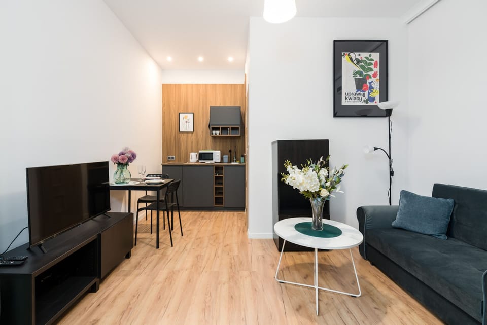 A bright and cozy living space with a sofa, round table, and decorative elements.
