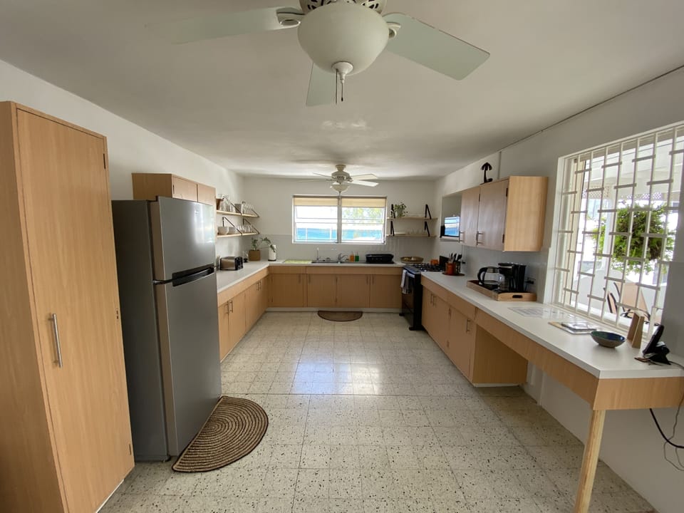 Fully equipped kitchen with a fridge, stove, toaster, oven and coffee maker