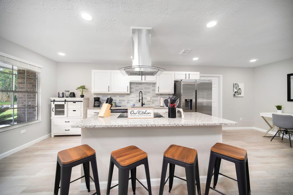 Sleek kitchen with island, stools, and appliances