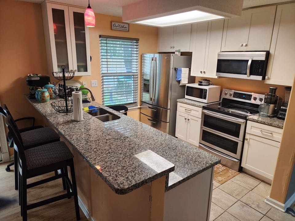The kitchen has a big refrigerator,  microwave, blender, keurig coffee maker etc