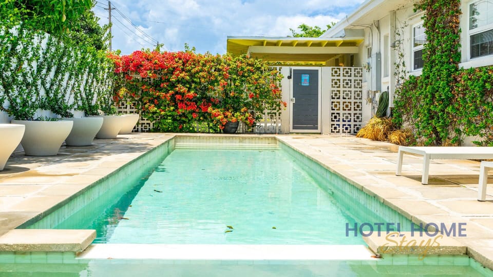 Private pool area surrounded by vibrant greenery and modern seating for relaxing.