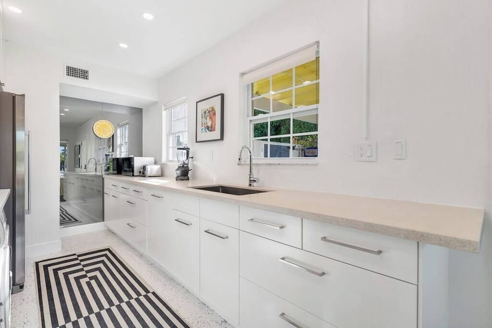 Modern kitchen with white cabinetry and a large countertop workspace