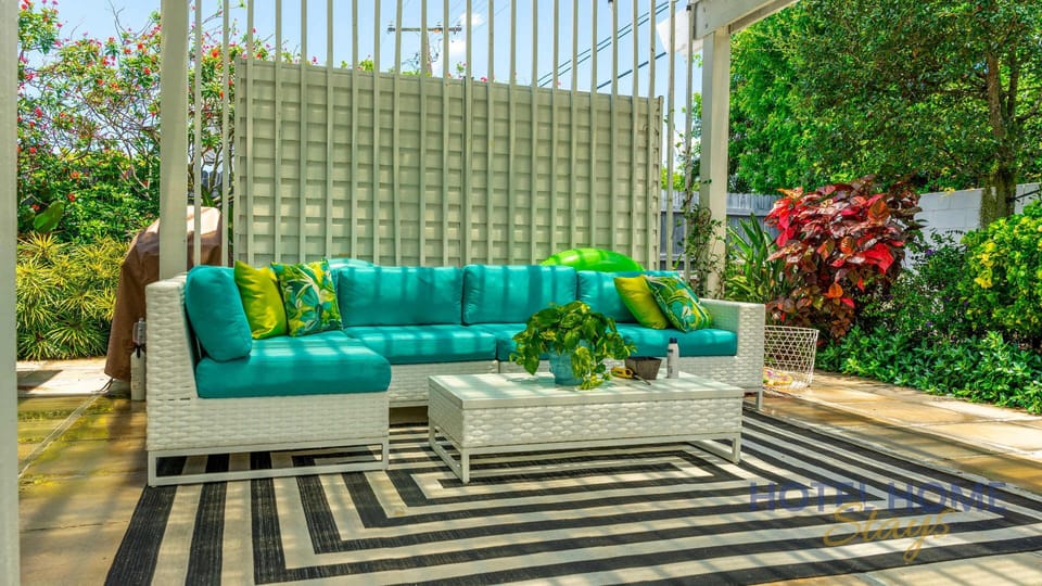 Outdoor seating area with turquoise cushions and lush garden surroundings